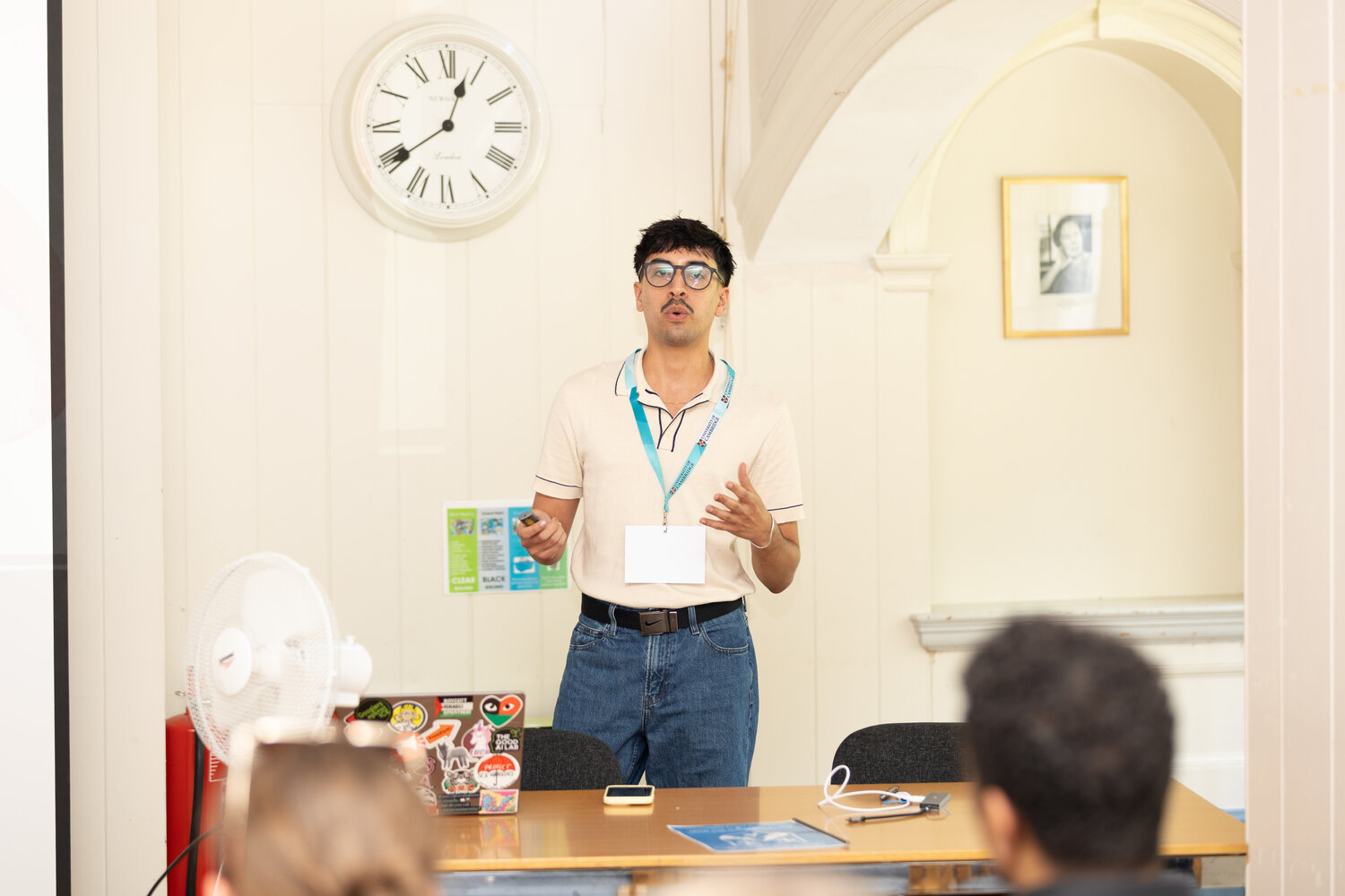 Man with glasses standing in front of class