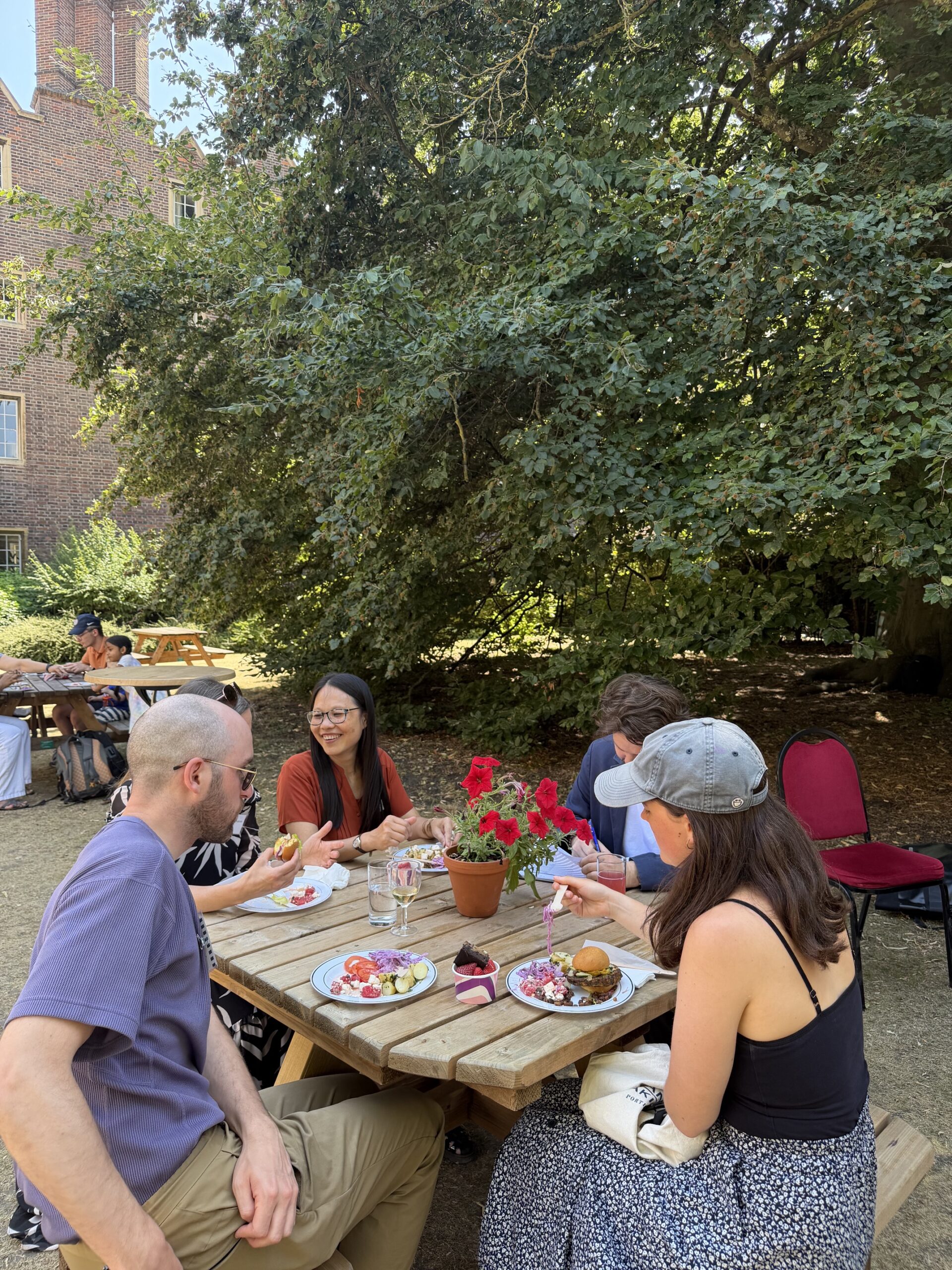Group of people sitting around a table outside chatting