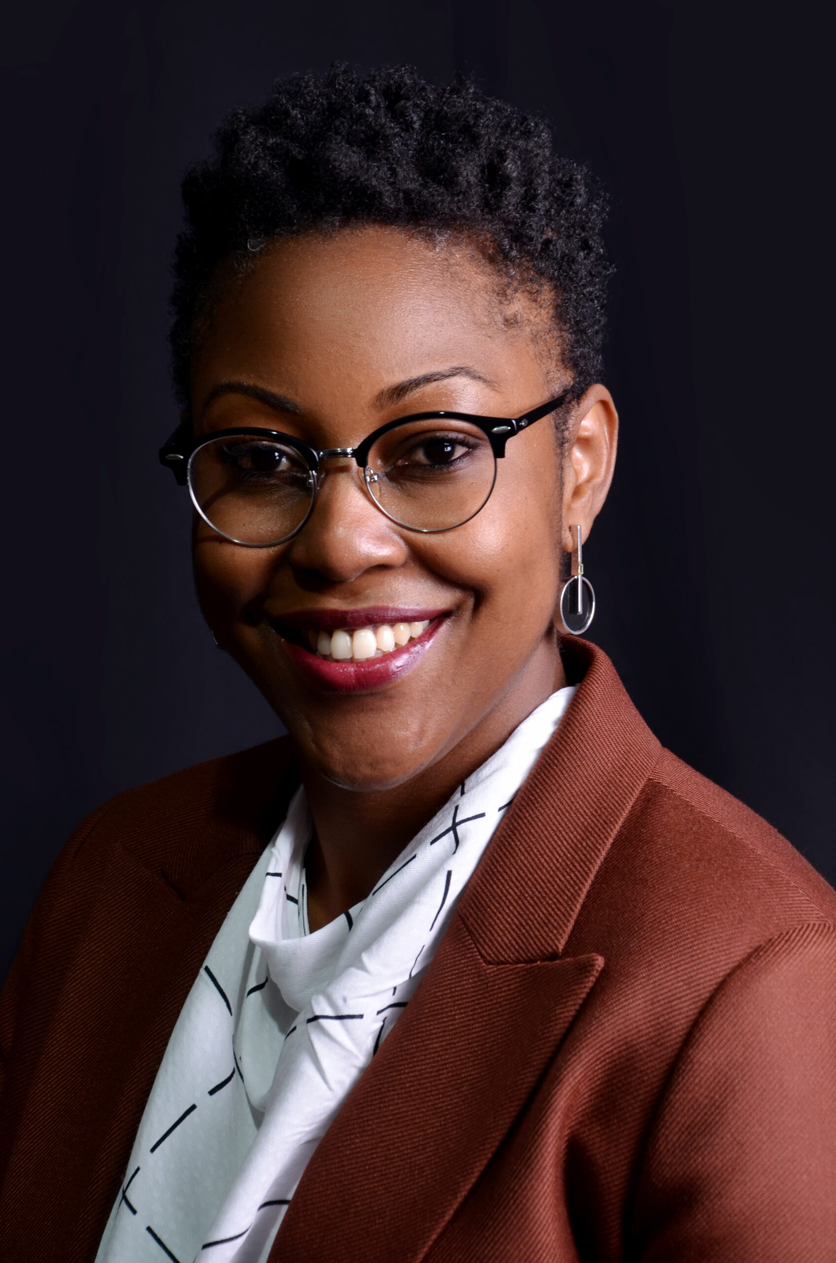 Woman in glasses and suit smiling