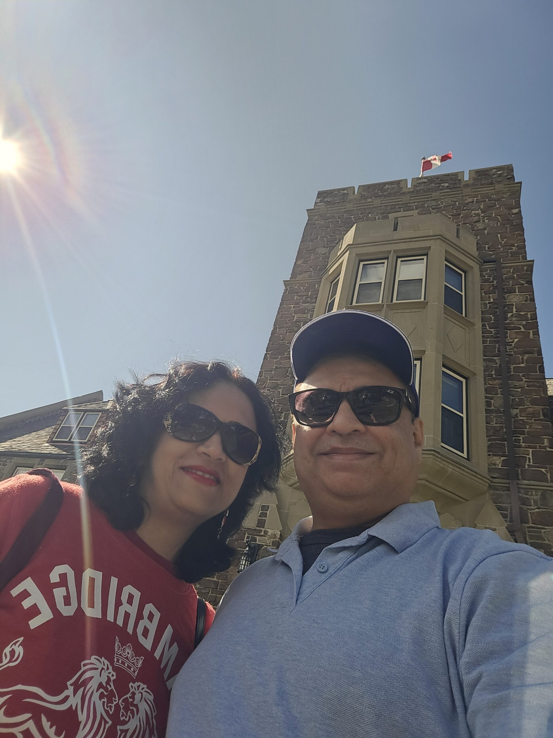 Man and woman in sunglasses standing in front of old building