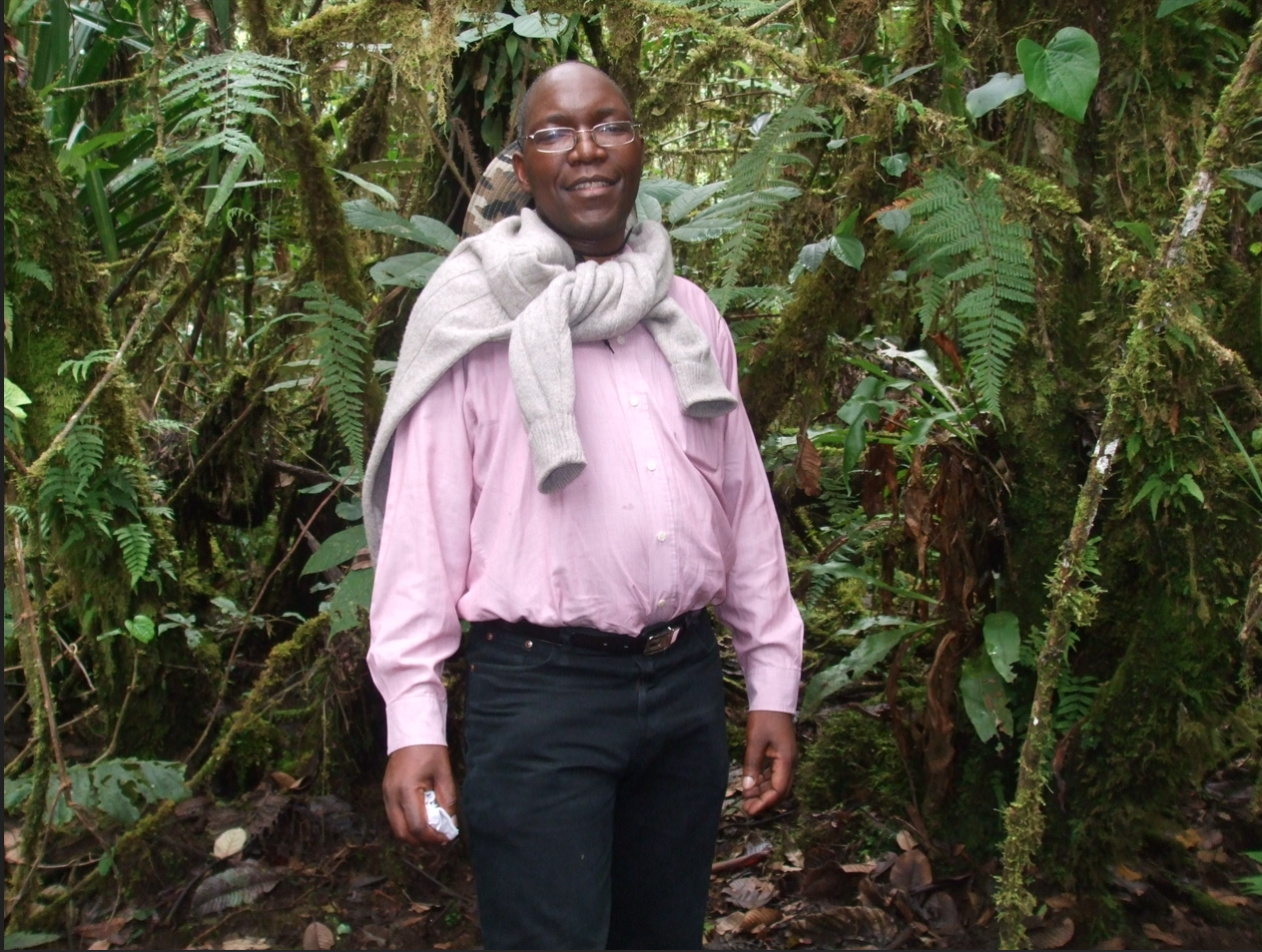Man with jumper around his neck against tropical background