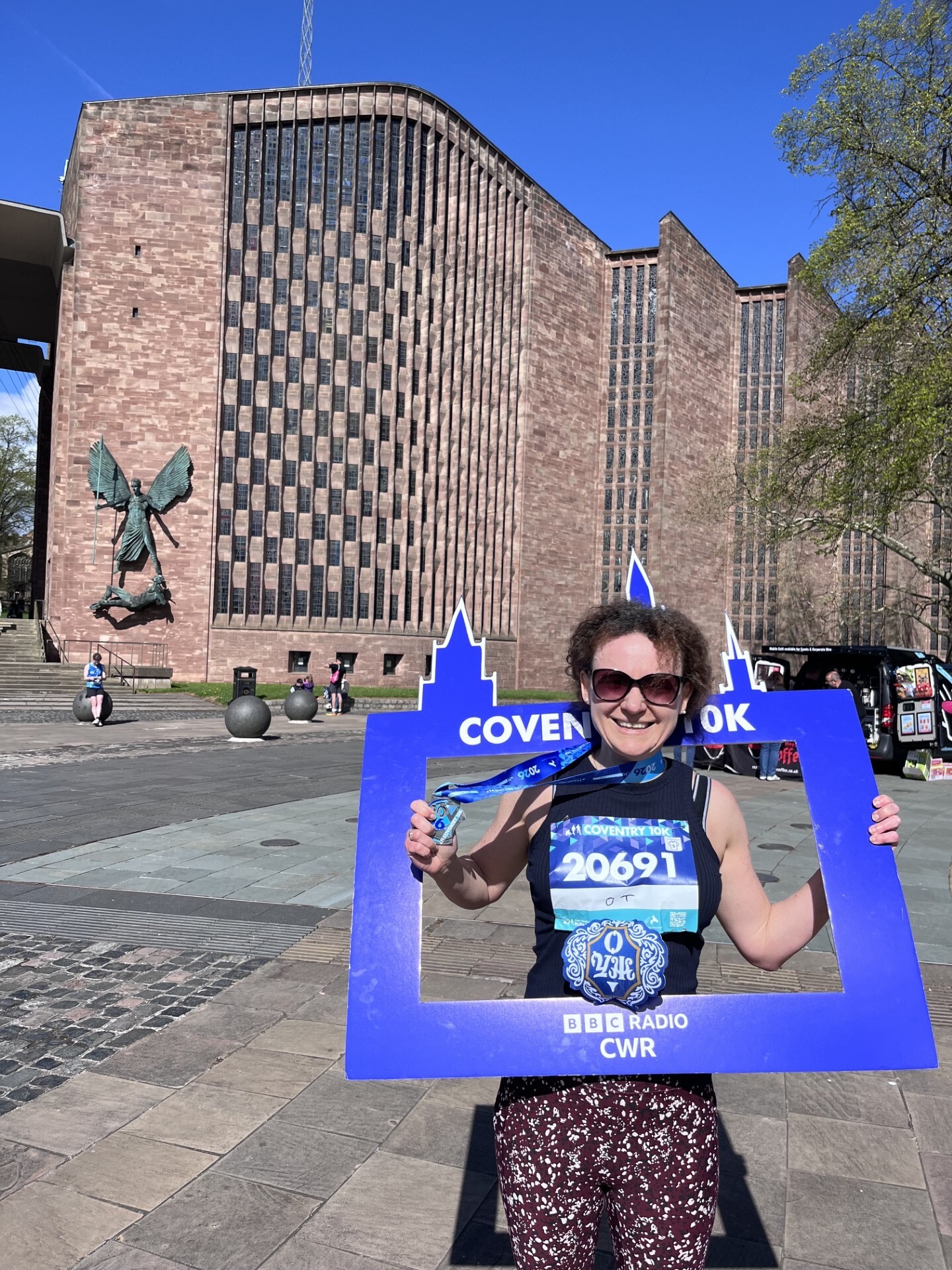 Woman with Coventry sign over her head and in running gear