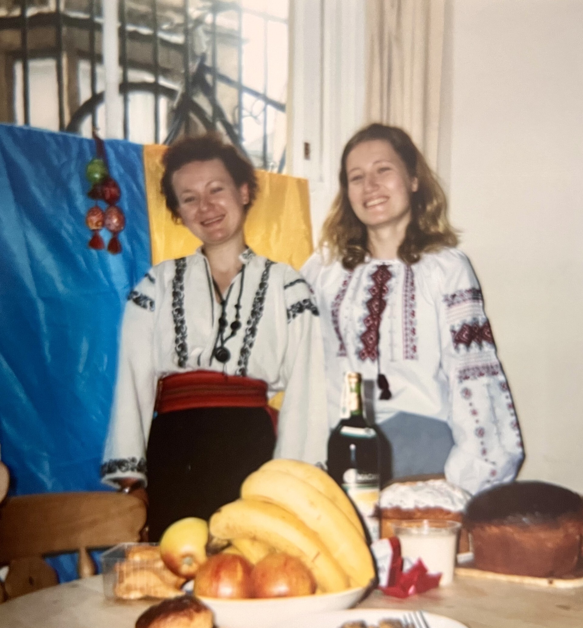 Two women standing in front of Ukrainian flag