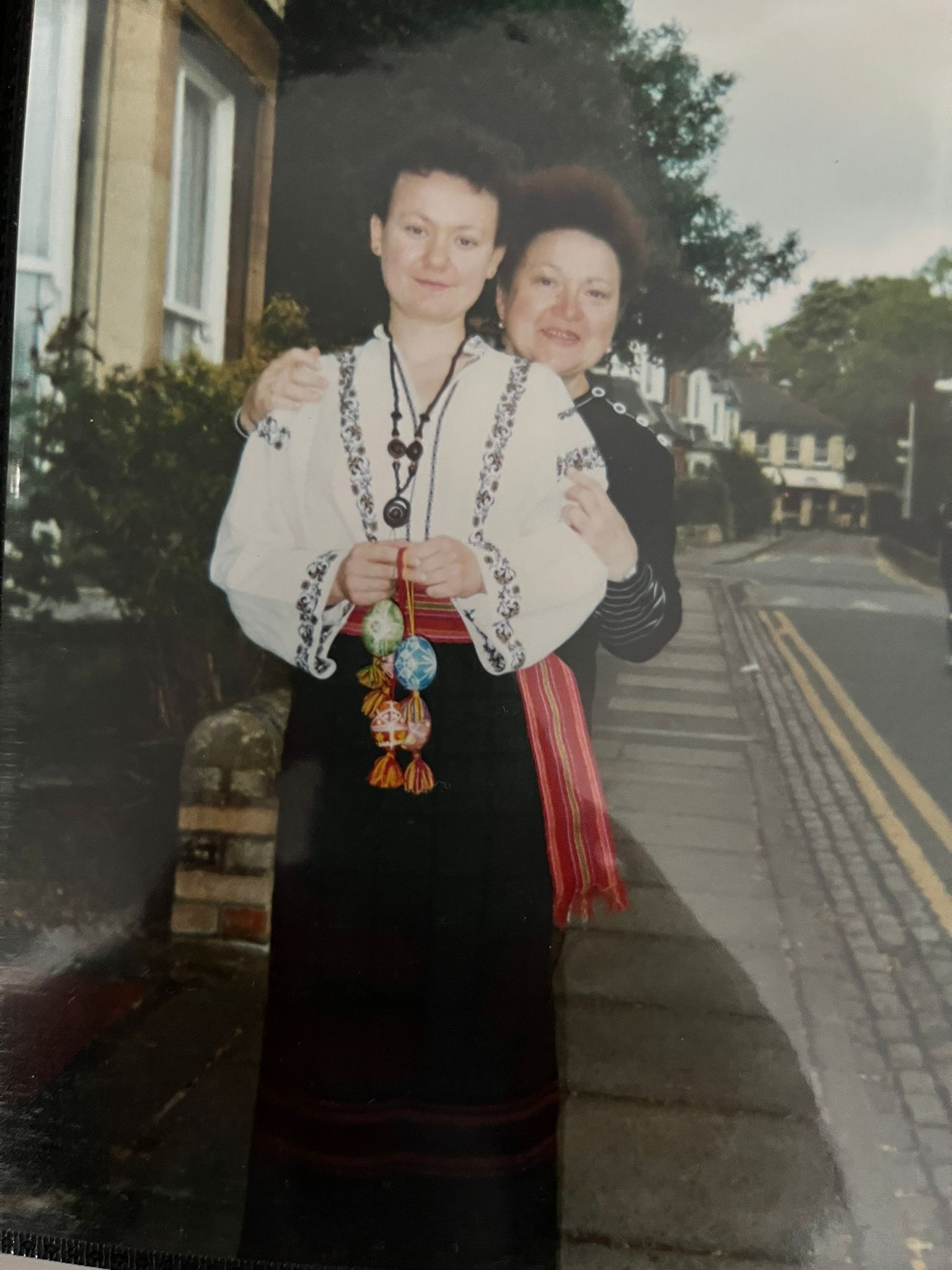 Two women standing with one wearing traditional Ukrainian dress