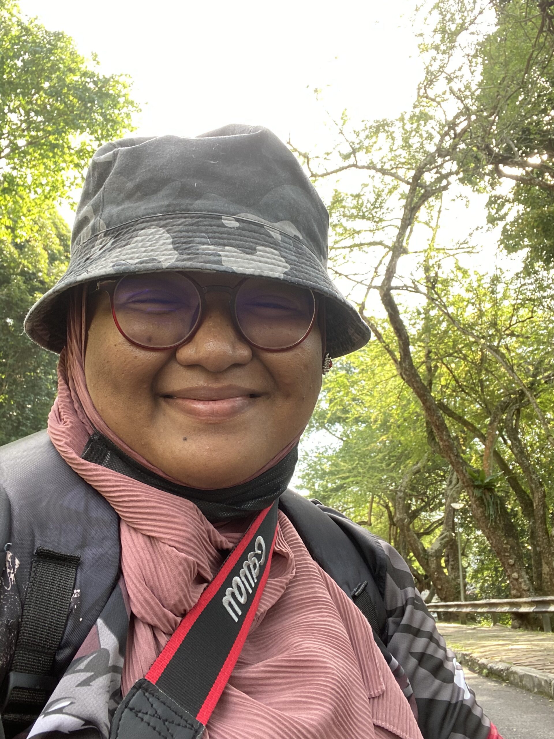 Close-up of woman in hat and glasses on campus