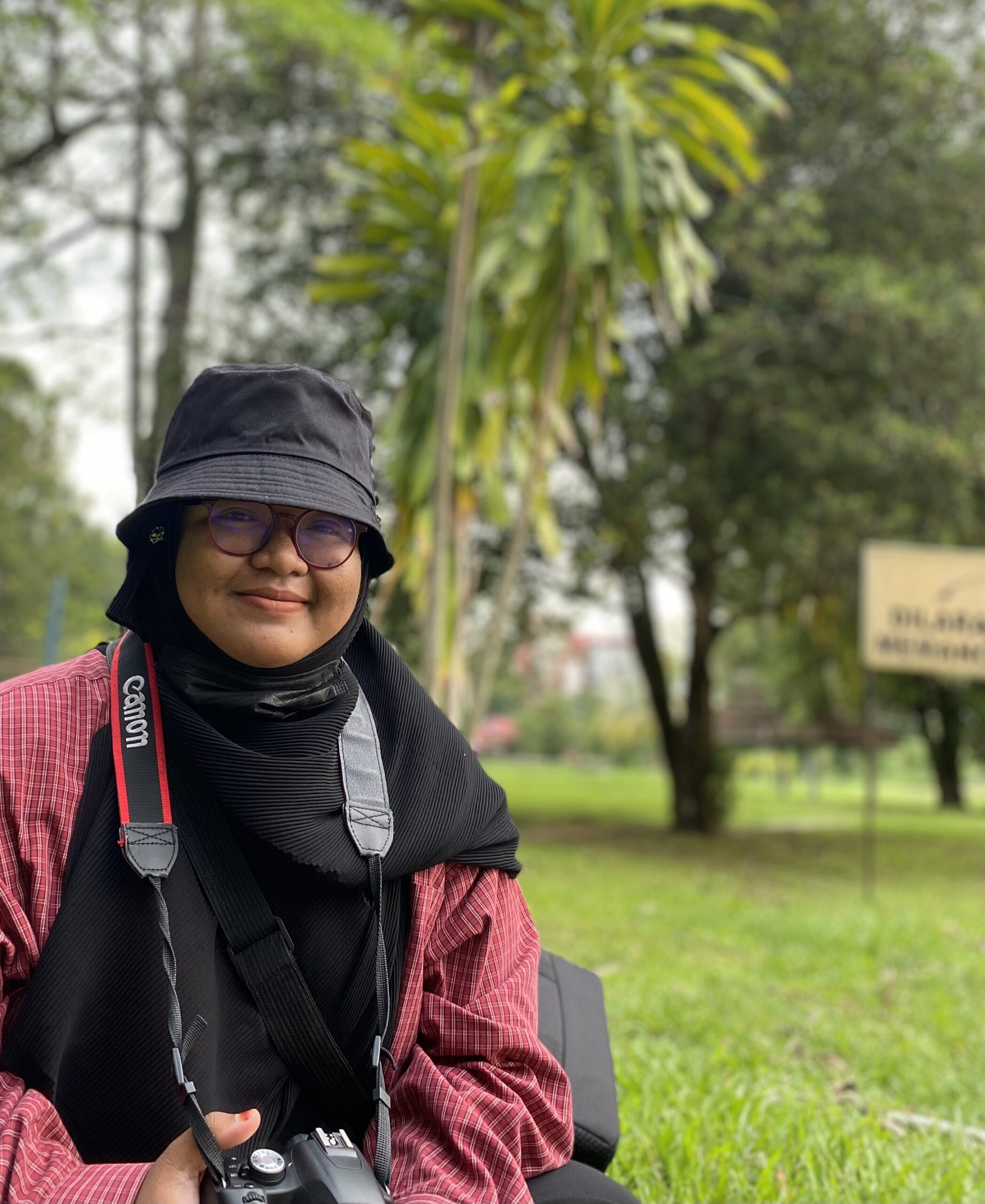 Woman in headscarf and hat in open space