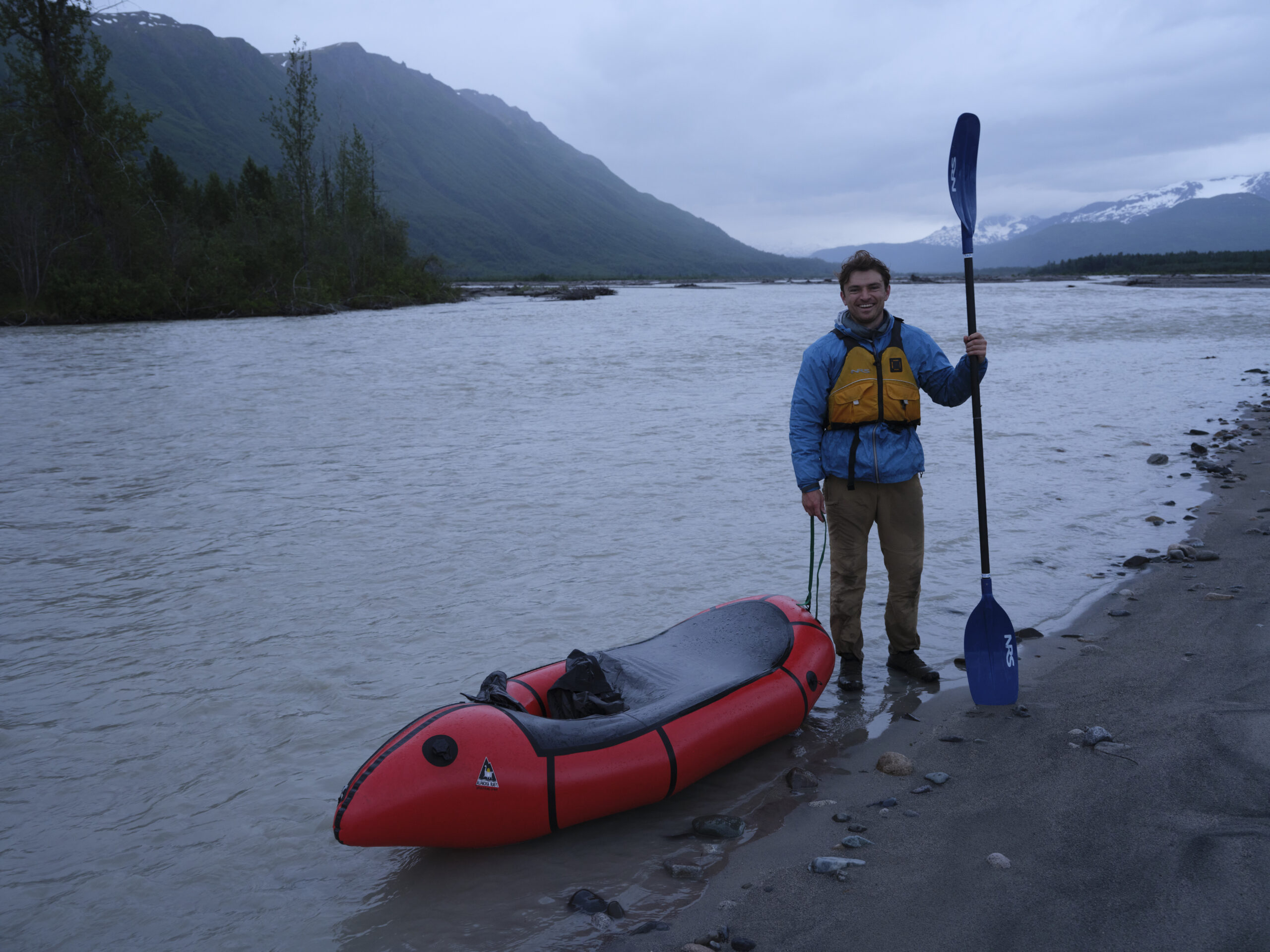 Man holding paddle beside canoe